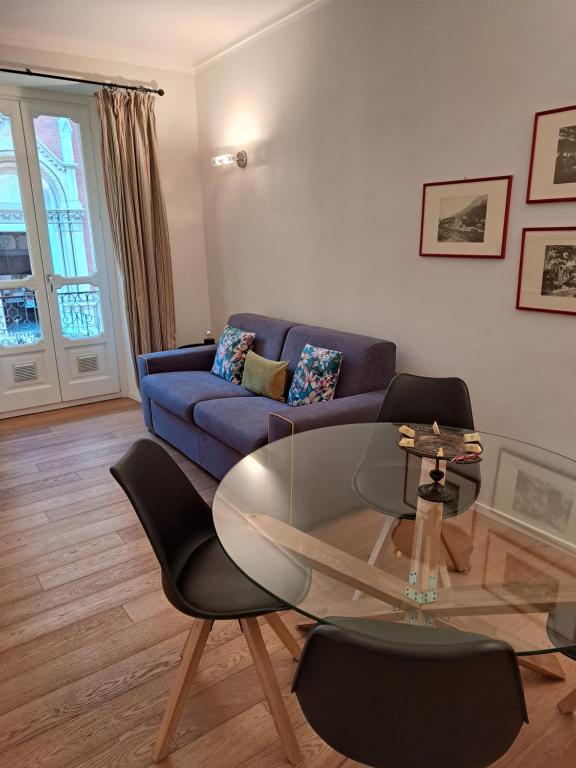 a living room with a blue couch and a glass table at Santantonio Suite, Porta Susa in Turin