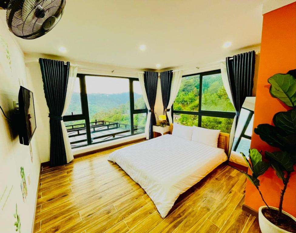 een slaapkamer met een bed en grote ramen bij Pine Forest House Dalat in Xuan An