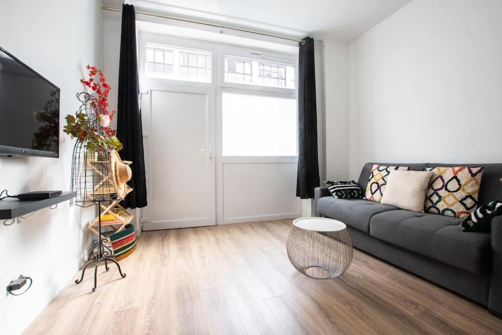 uma sala de estar com um sofá e uma janela em HSH Traversière-Boulogne-Billancourt I Appartement 4P em Boulogne-Billancourt
