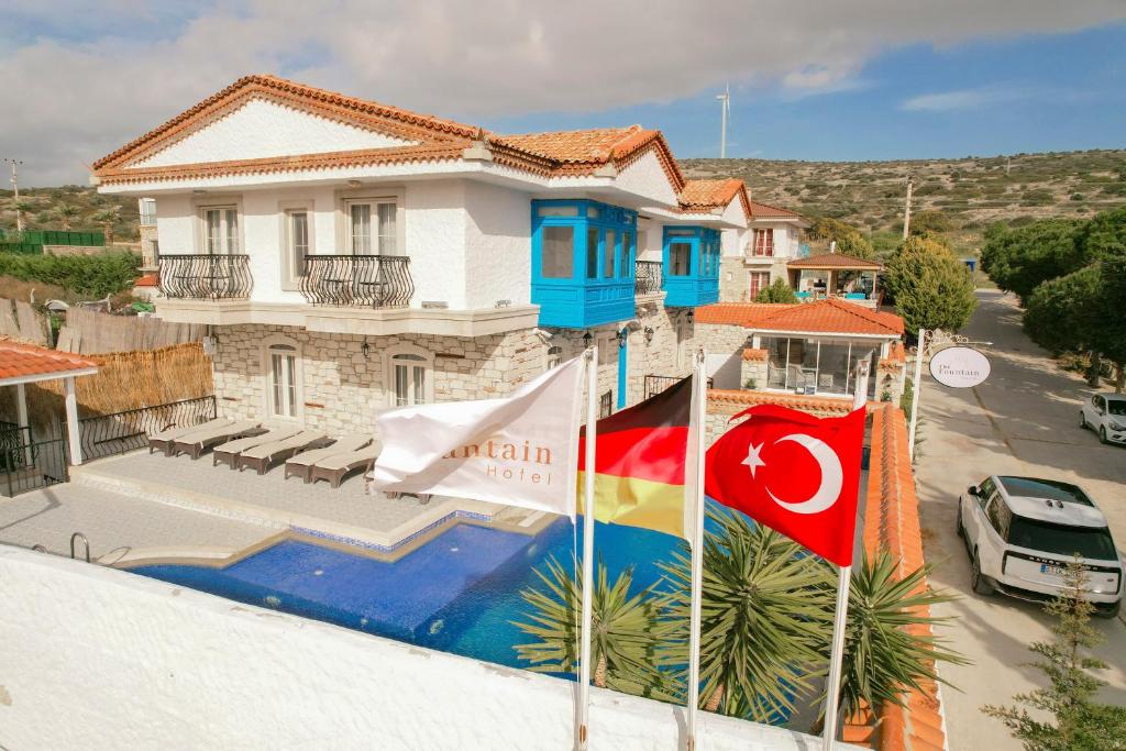a house with two flags in front of it at The Fountain Hotel in Cesme