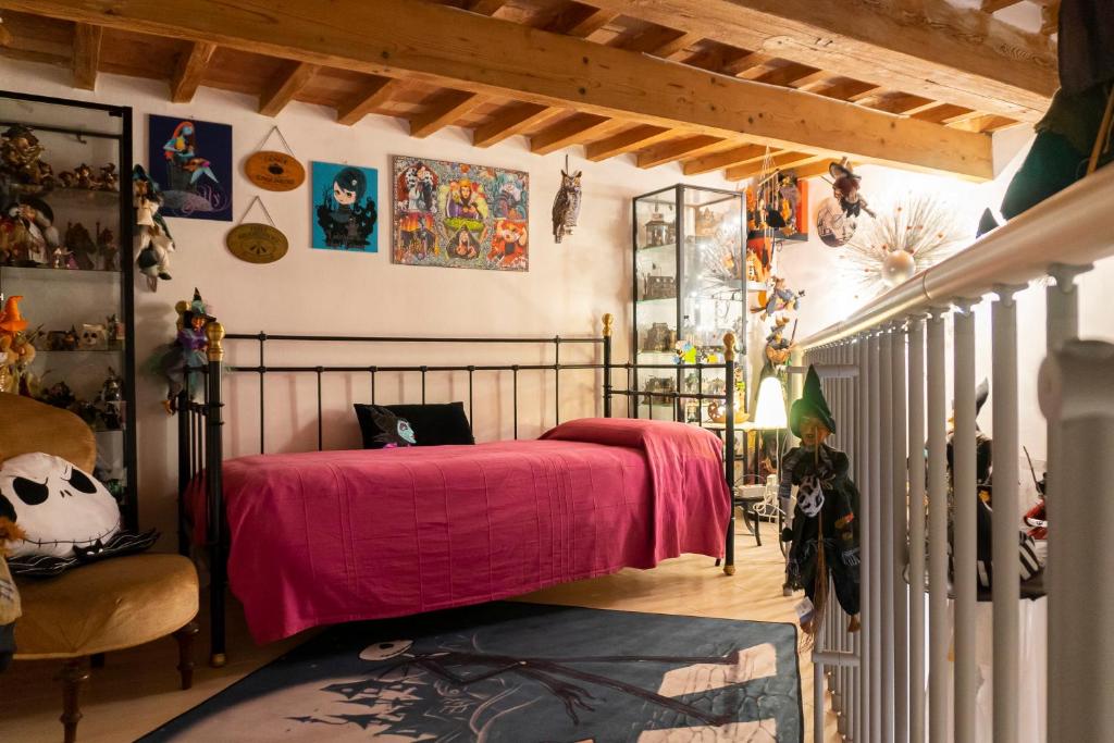 LE STREGHE rooms e art con garage في ليفورنو: غرفة نوم بسرير ولحاف وردي