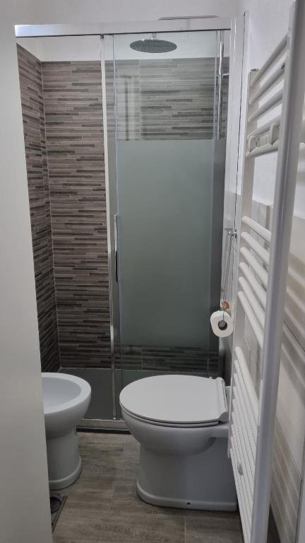 La salle de bains est pourvue de toilettes et d'une douche en verre. dans l'établissement La piccola Perla, à Savone