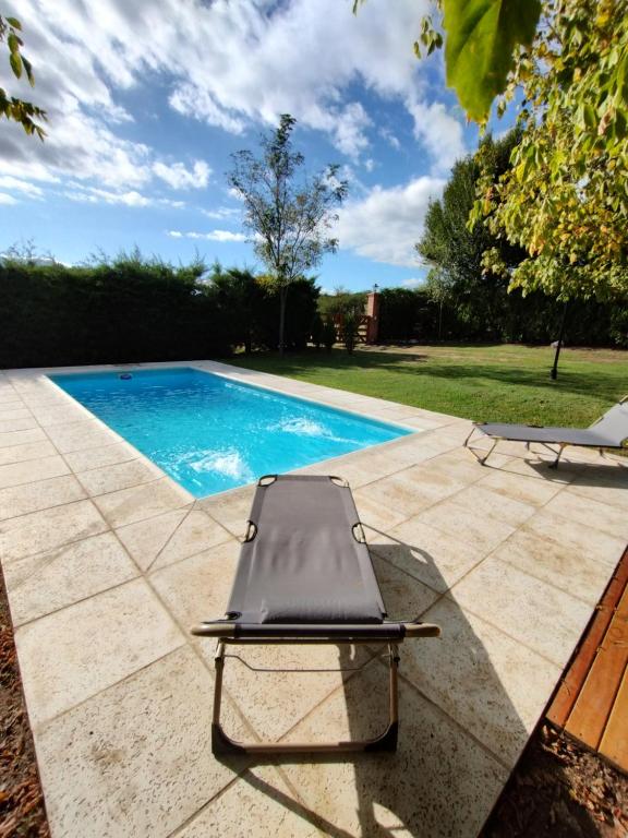 een ligstoel naast een zwembad bij Tres Deseos in Villa Cura Brochero