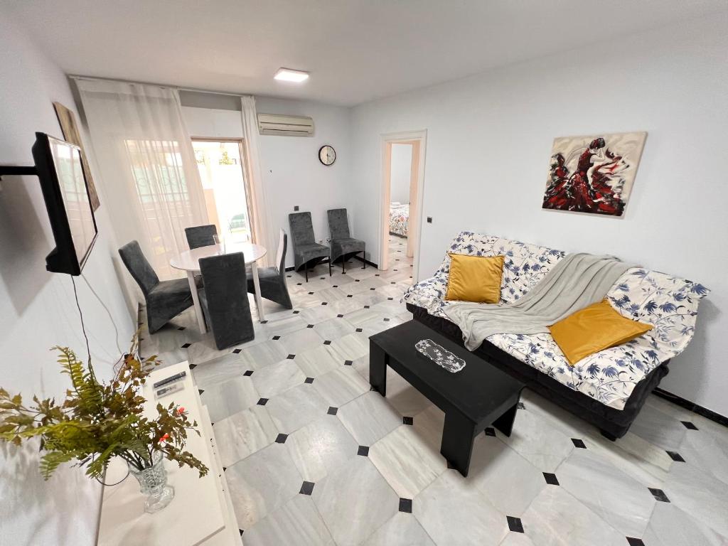 salon z kanapą i stołem w obiekcie Pedregalejo Playa, Piscina y Parking w Maladze