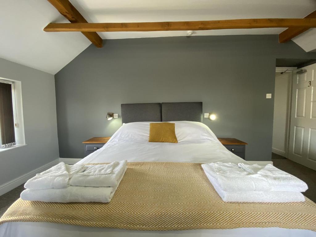 a bedroom with a large bed with two towels on it at The Roade House in Northampton