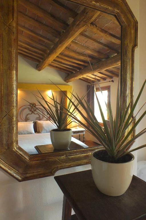 two potted plants sitting on a table in front of a mirror at Corte di Maggio B&B in Imola
