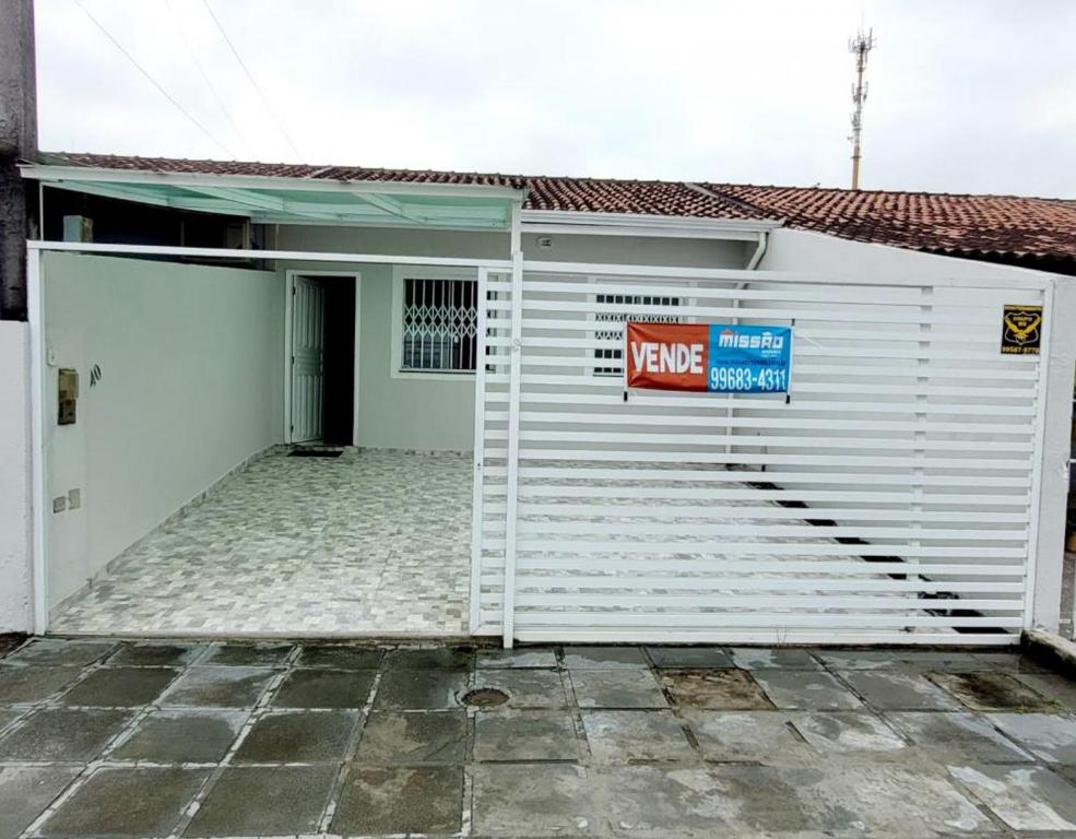 a large white garage with a keep sign on it at Casa mobiliada recém reformada in Matinhos