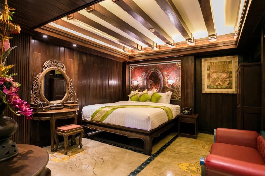 a bedroom with a bed and a table and a mirror at Namton Boutique Hotel in Chiang Mai