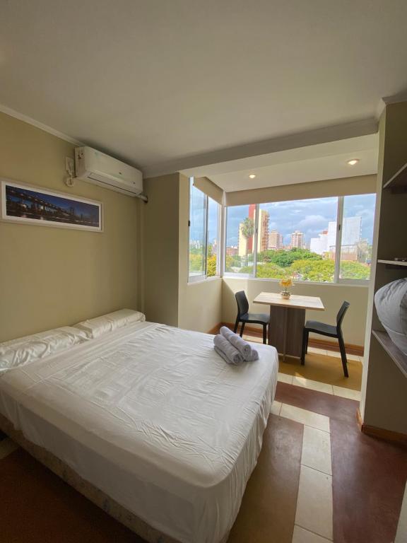 een slaapkamer met een bed, een tafel en een raam bij Los geranios Villa Sarita Posadas - 3B in Posadas