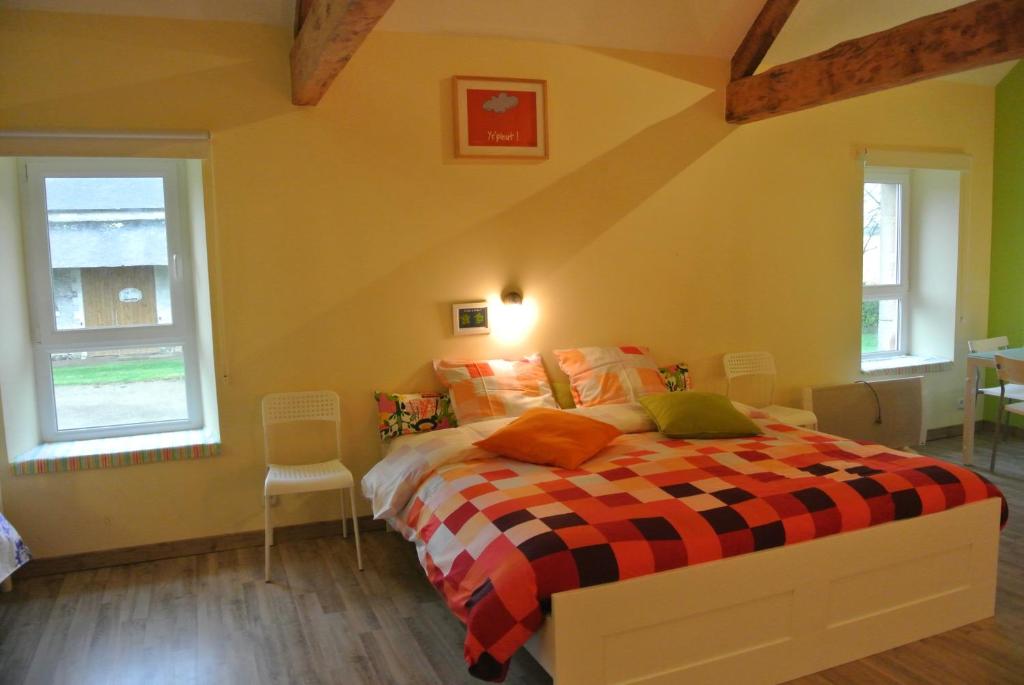 a bedroom with a bed with a checkered blanket at Chambres d&#39;Hôtes La Fresnée in Mosles