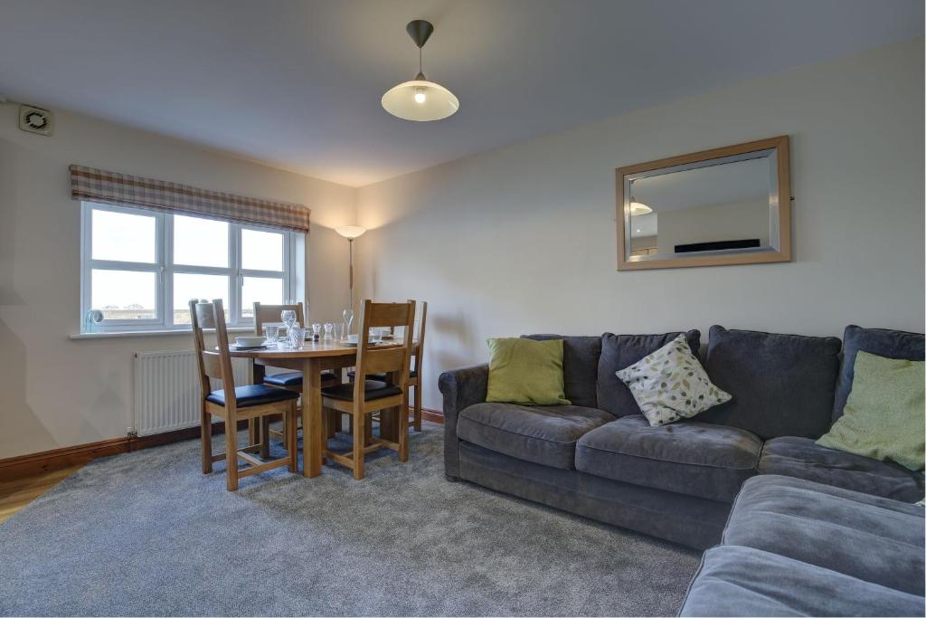 a living room with a couch and a table at Bakers Yard in Wells next the Sea