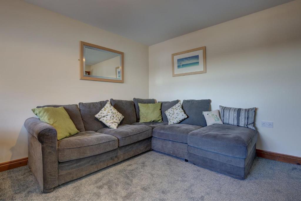 a living room with a couch and a mirror at Bakers Yard in Wells next the Sea