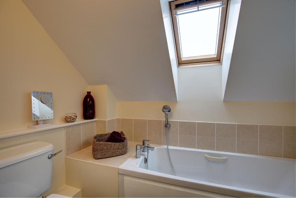 a bathroom with a sink and a toilet and a window at Bakers Yard in Wells next the Sea