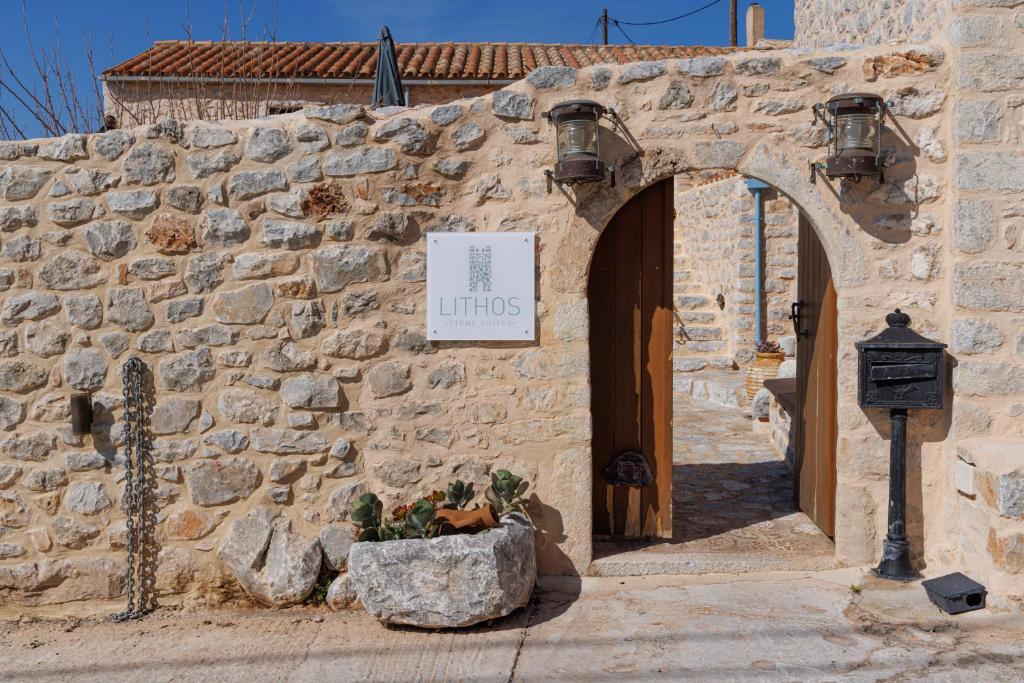 阿里奧波利斯的住宿－Lithos Stone Suites，石头建筑的入口,上面有标志