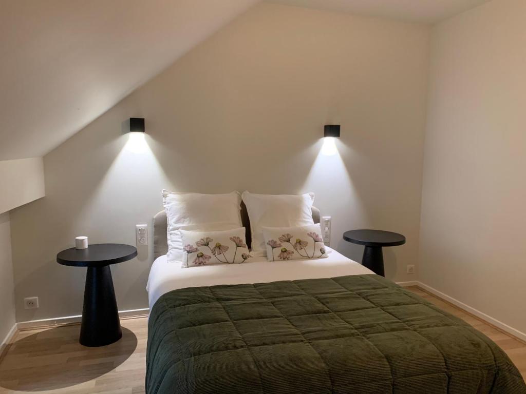 ein Schlafzimmer mit einem großen Bett mit zwei Tischen in der Unterkunft Gîte Les Mijoteurs in Rocamadour