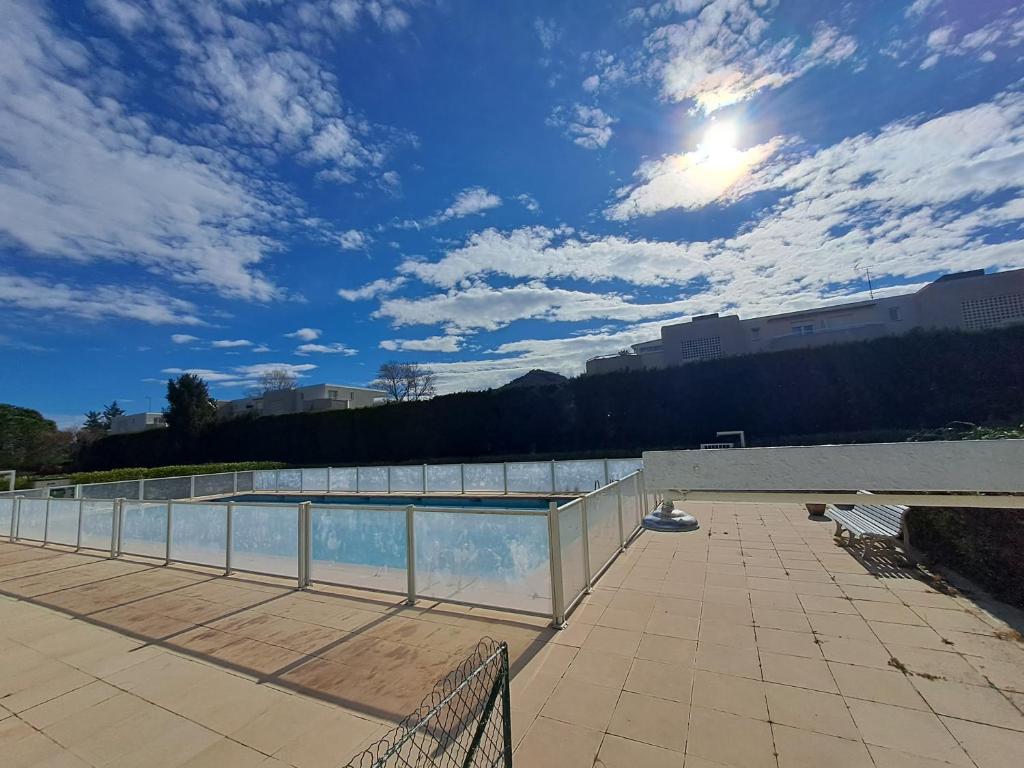een uitzicht op een zwembad met een bewolkte hemel bij Situation idéale au calme et tout confort ! in Mandelieu-la-Napoule