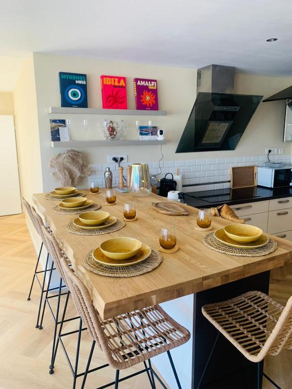 une cuisine avec une table en bois et des plaques de cuisson. dans l'établissement New Cosy Flat Saint Tropez, à Saint-Tropez