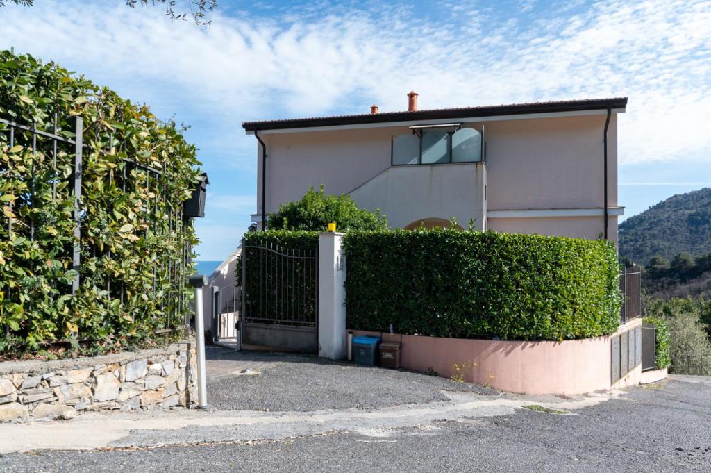 a house with a hedge in front of a building at L'Ulivo di Cecilia in Alassio