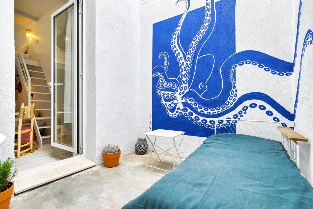 une fresque d'une pieuvre sur le côté d'un bâtiment dans l'établissement L'Octopus - Petit patio estival, à Marseille