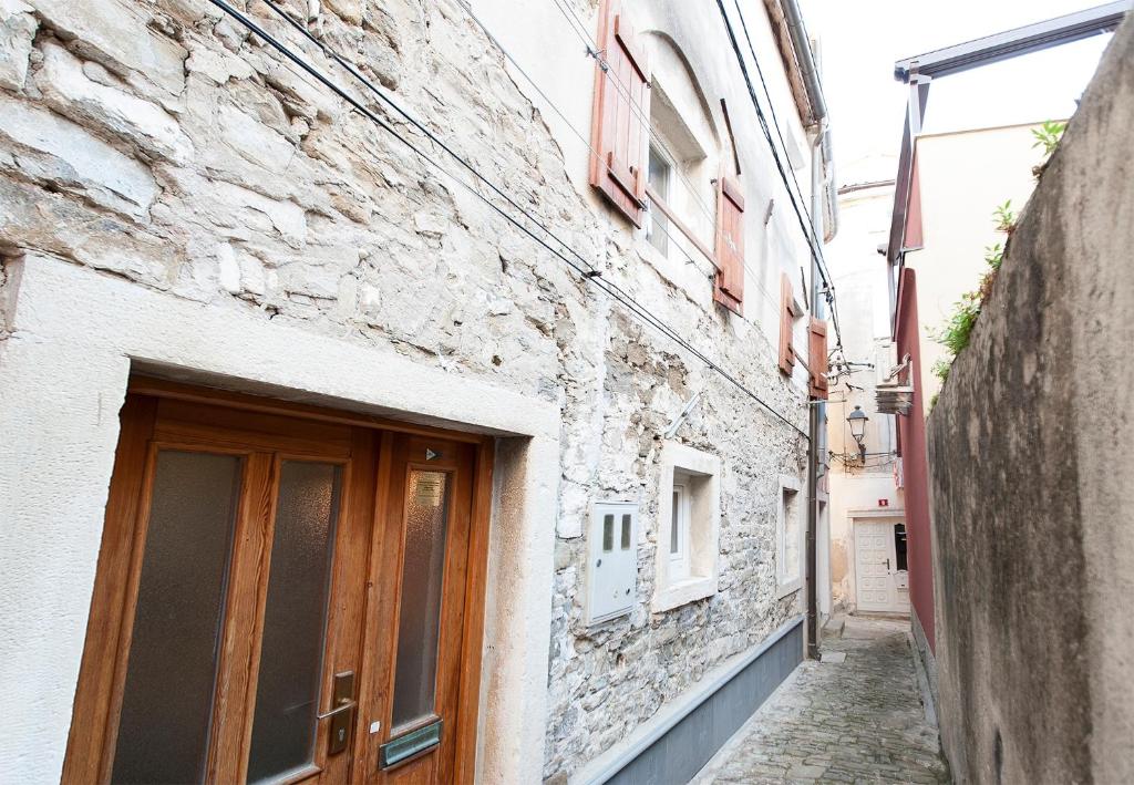 an alley in an old building with a wooden door at Sailing House Piran in Piran