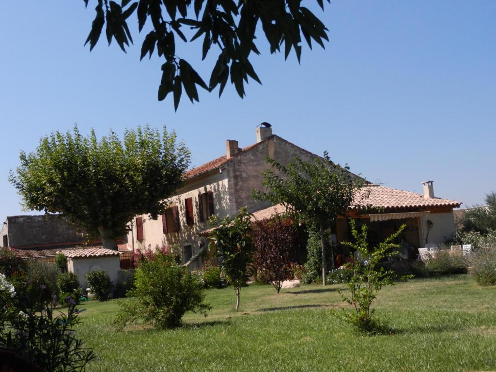 una casa vieja en un campo con un patio en La Fenière aux Hirondelles en Orange