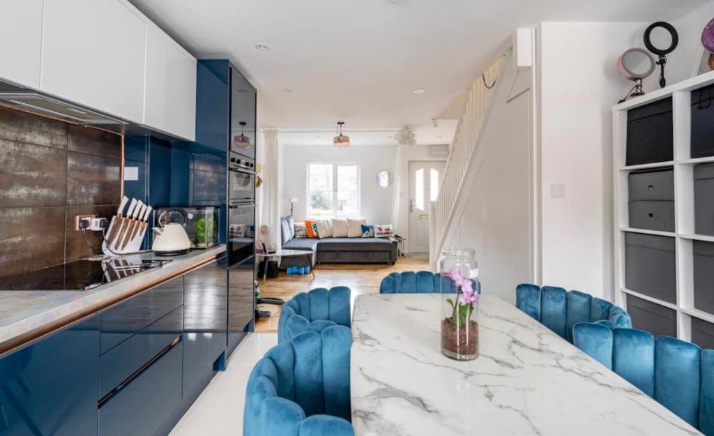a kitchen and living room with a table and blue chairs at Monalychee in London