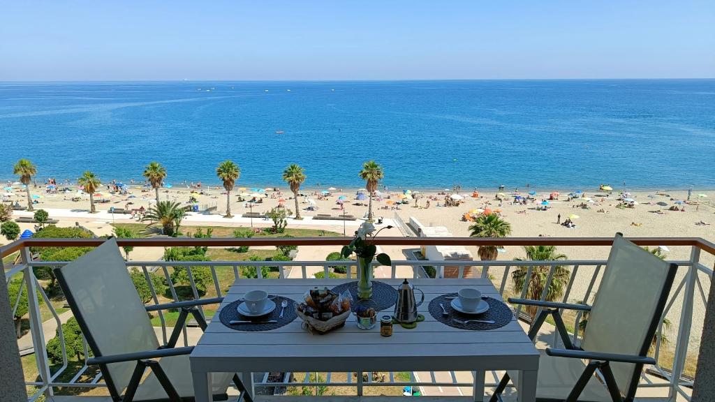 Una mesa en un balcón con vista a la playa. en Maremare, really on the Beach, with private parking, en Savona