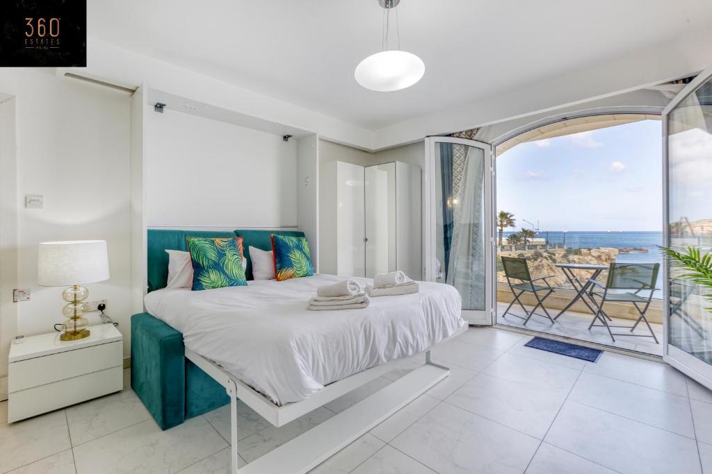 um quarto com uma cama e vista para o oceano em Seafront, Studio home with Private Seaview terrace by 360 Estates em St. Paul's Bay