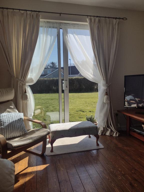 a living room with a window and a couch and a television at Swilly Cottage, Portstewart in Portstewart
