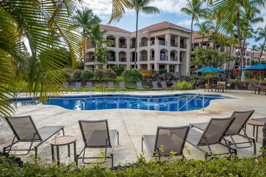 ein Resort mit einem Pool und Stühlen sowie einem Gebäude in der Unterkunft Shores at Waikoloa #132 condo in Waikoloa