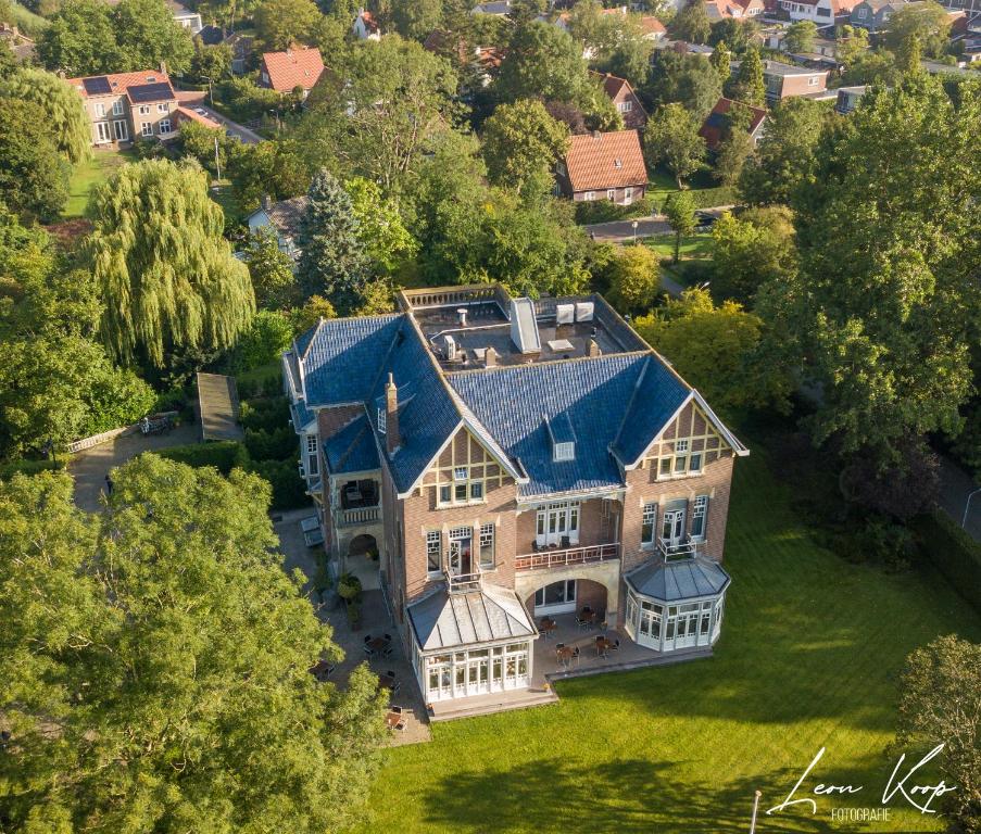 eine Luftansicht eines großen Hauses mit blauem Dach in der Unterkunft Rijksmonument Hotel de Sprenck in Middelburg