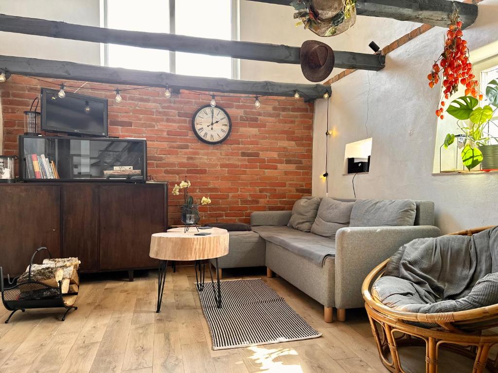 a living room with a couch and a brick wall at Apartament Loftowy- Bory Tucholskie in Świekatowo