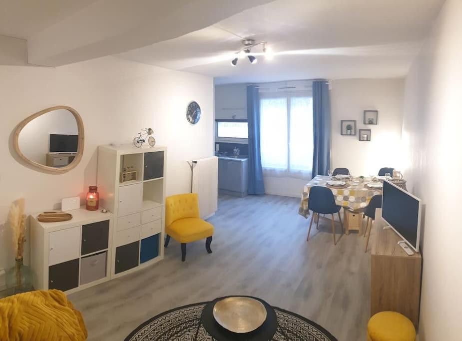 a living room with a table and a dining room at Charmant studio avec place de parking in Nancy