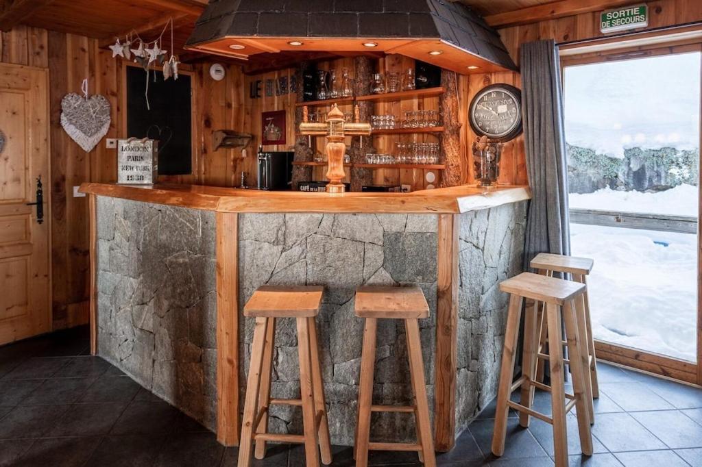 a bar in a cabin with stools and a clock at Le Dahu - 8-kamer chalet + sauna & bar 14 personen in Landry