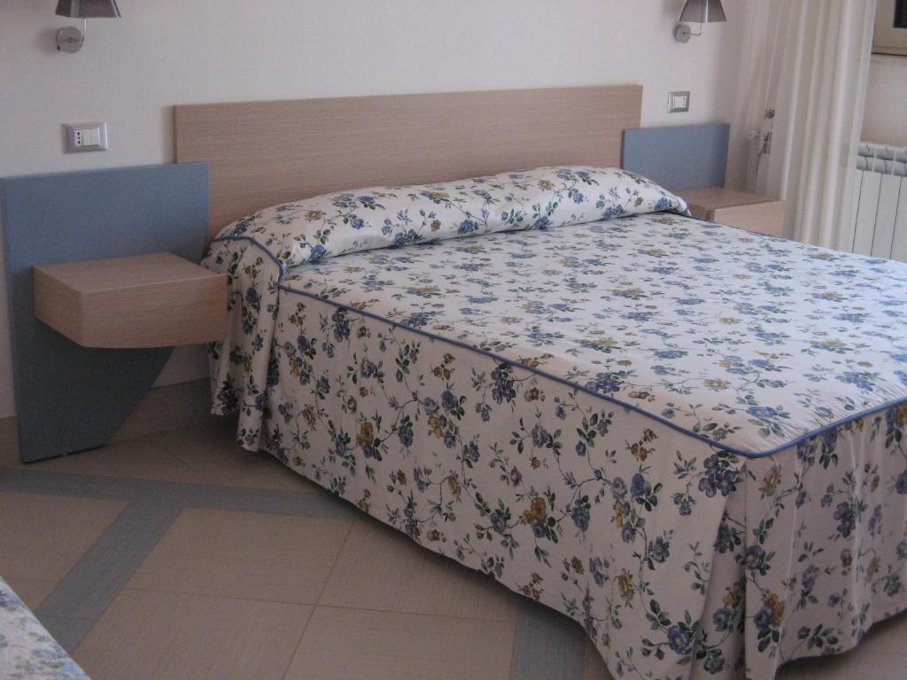 a bedroom with a bed with a floral bedspread at Masseria Asciano in Ostuni