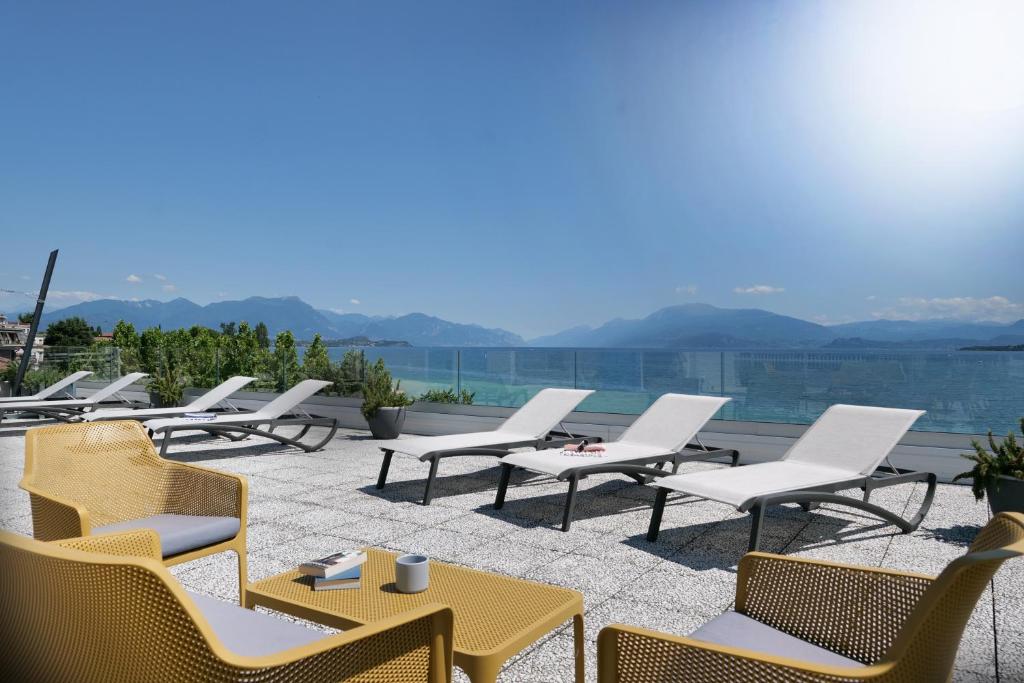 a group of chairs and tables on a patio at Hotel Riviera in Desenzano del Garda