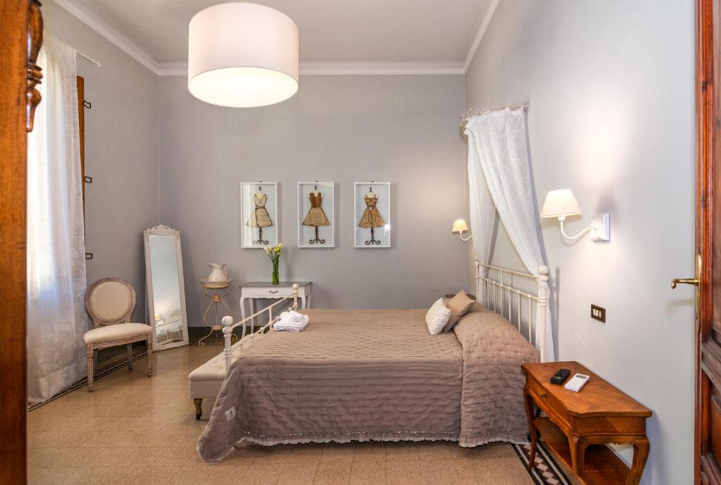 a bedroom with a bed and a table and a lamp at Villa Ricci Suites in Lucca