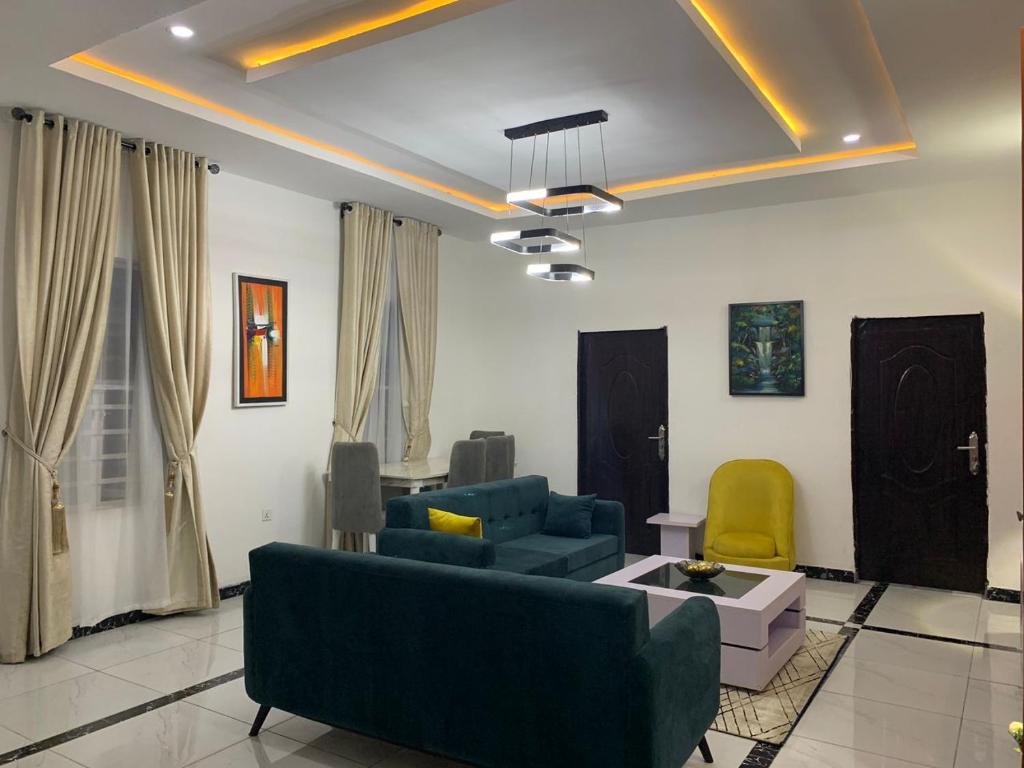 a living room with a blue couch and chairs at Luxury 1 Bedroom & Parlor Service Apartment with beautiful Amenities in Awoyaya