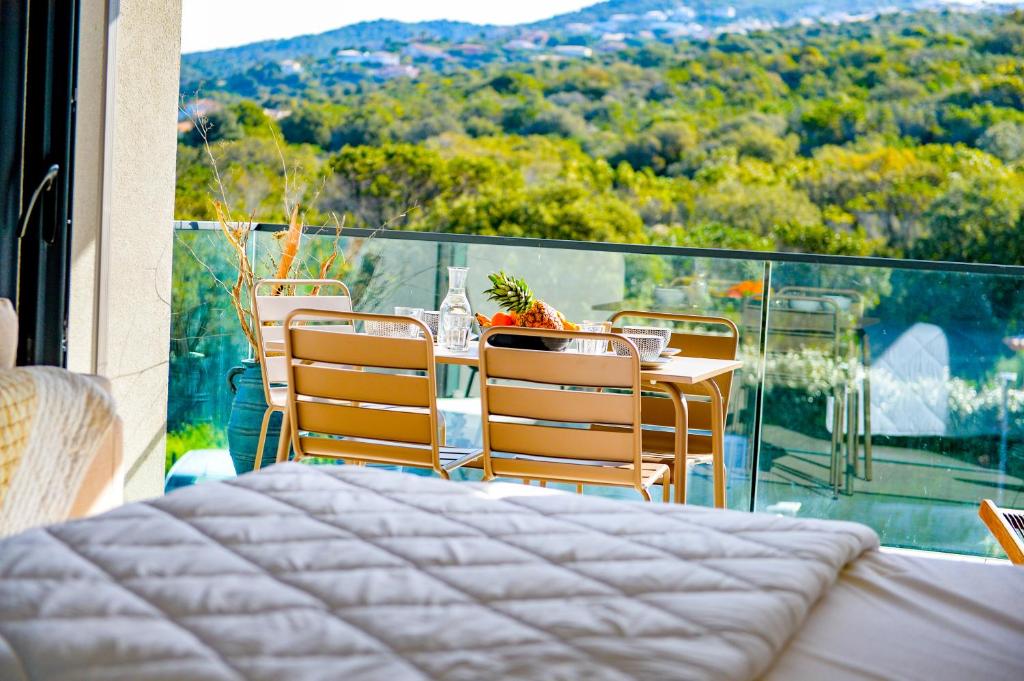 een tafel en stoelen op een balkon met uitzicht bij Marion - Plage à pied, Clim, Wifi - Agosta in Albitreccia