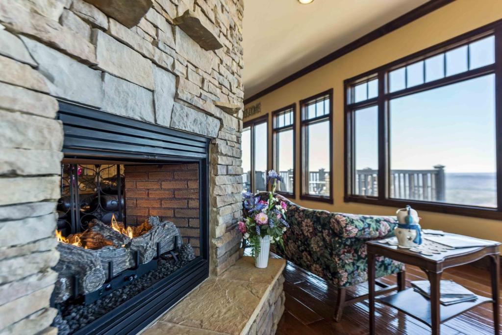 a living room with a stone fireplace with a table at Suite Lookout At The Mentone Mountain View Inn in Mentone