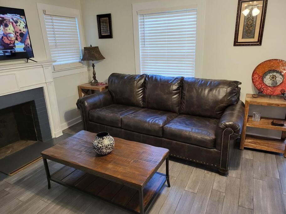 sala de estar con sofá de cuero y mesa de centro en 5. Cozy cabin in Guntersville, en Guntersville