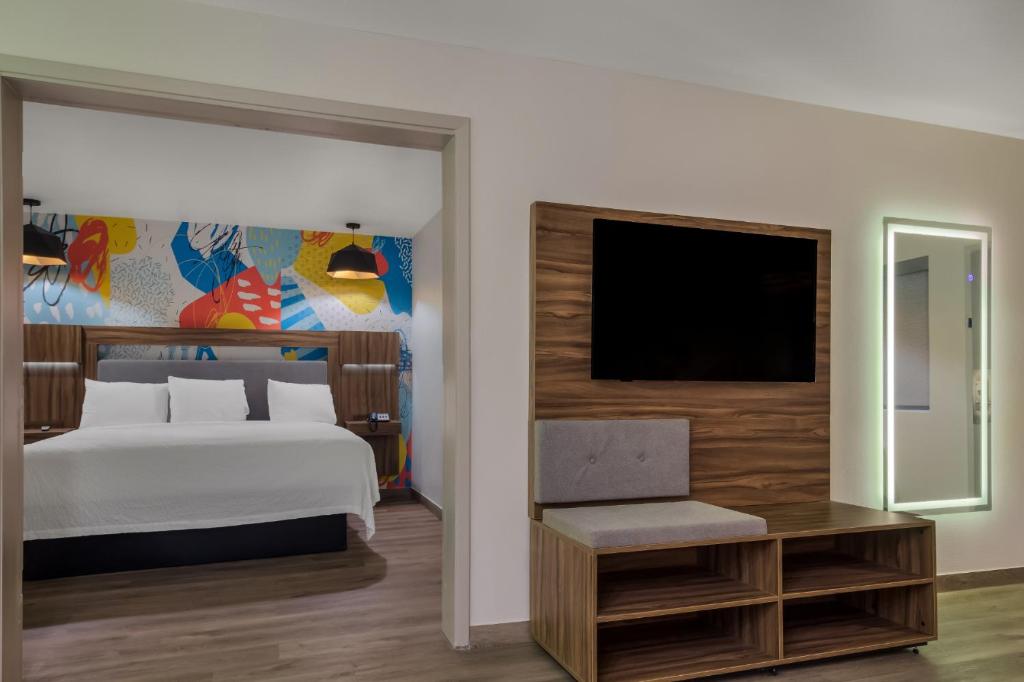 a bedroom with a bed and a flat screen tv at Signature Inn Houston Galleria in Houston