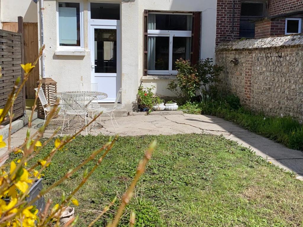 une maison avec une porte blanche et une cour dans l'établissement Maison avec jardin et parking, au centre d'Etretat, à Étretat