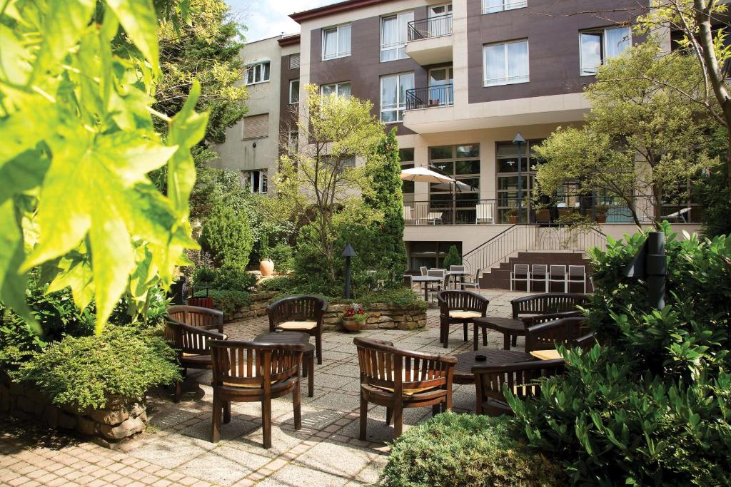 a patio with tables and chairs and a building at Adina Apartment Hotel Budapest in Budapest