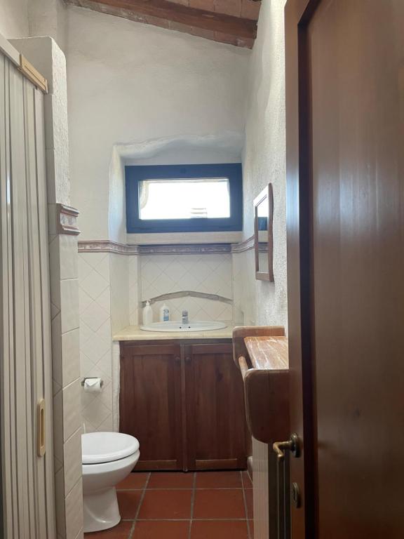a bathroom with a toilet and a sink and a window at Torre Di Ponzano in Barberino di Val dʼElsa