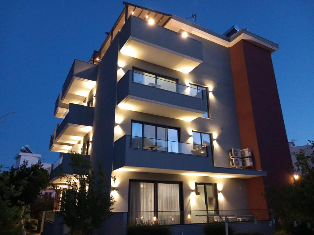 a tall building with lights on it at night at Hotel Ksamili in Ksamil