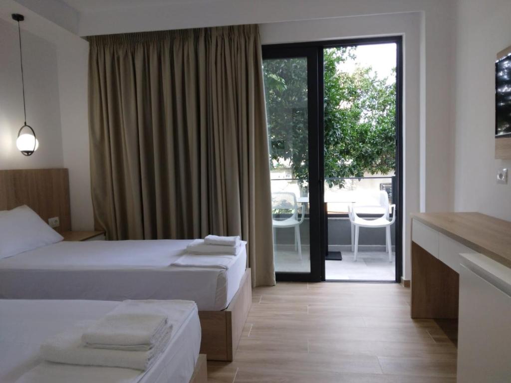 a hotel room with two beds and a balcony at Hotel Ksamili in Ksamil