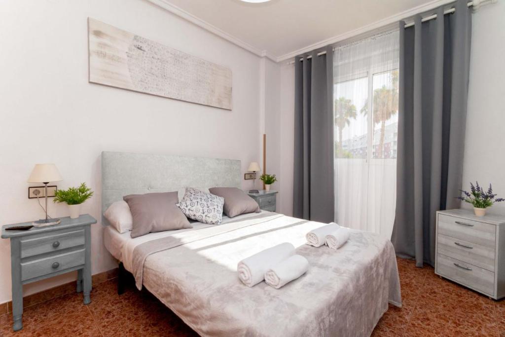 a bedroom with a bed with two towels on it at Apartamentos Villa Madrid in Torrevieja