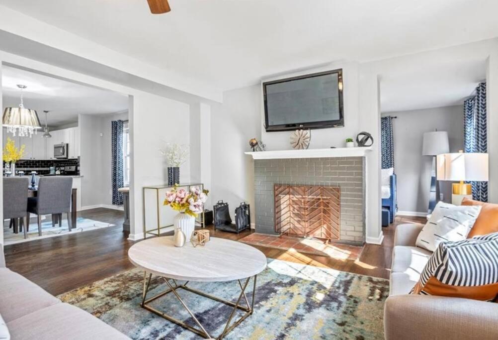 a living room with a fireplace with a tv above it at Modern 3BD Cottage Home w/Private HotTub in Atlanta