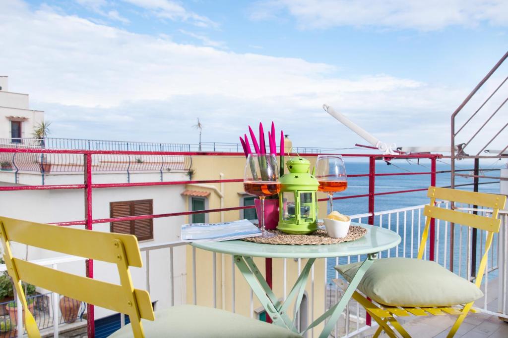 a table on a balcony with a view of the ocean at Luigi's room - De Vivo Realty Meta di Sorrento in Meta